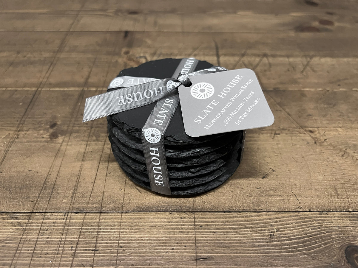 A pack of 6 hand-cut round shaped Welsh slate coasters tied with 'Slate House' ribbon