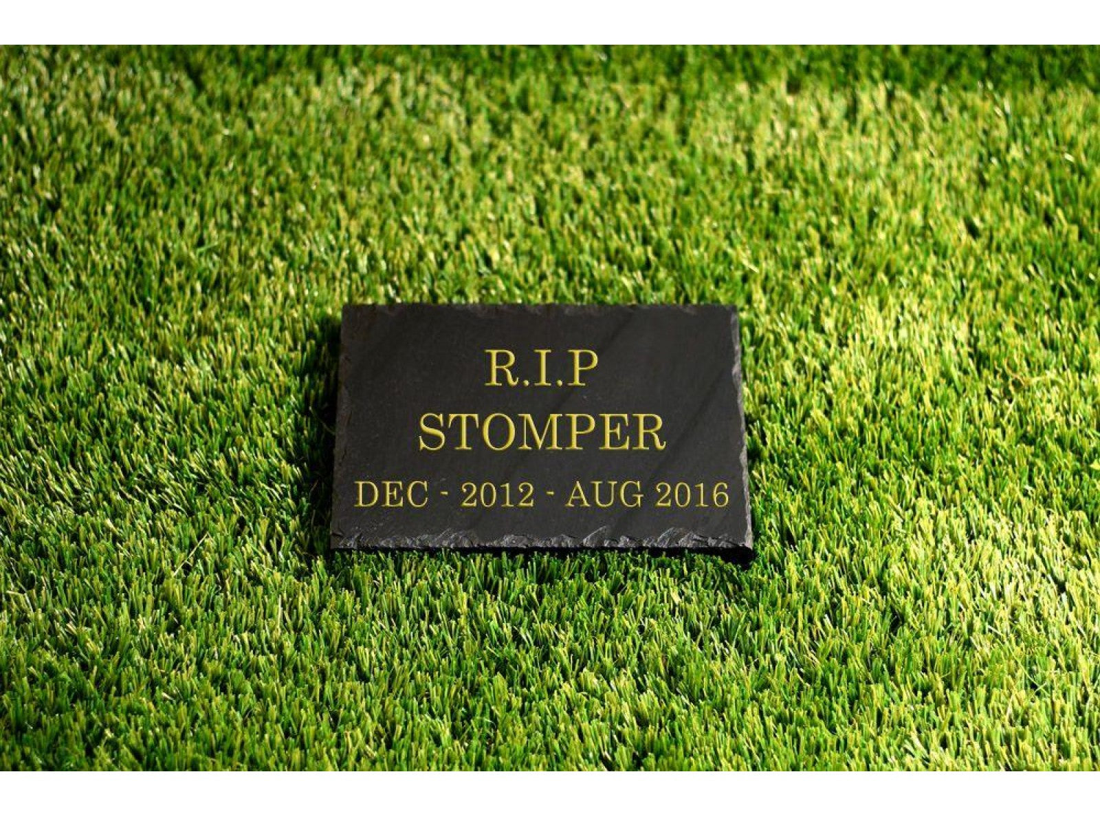 A 200mm x 150mm Welsh slate flat memorial that lays on the ground, sentimental words deep engraved and colour filled on it