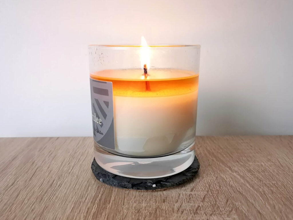 A Slate House wood wick candle with a full melt pool
