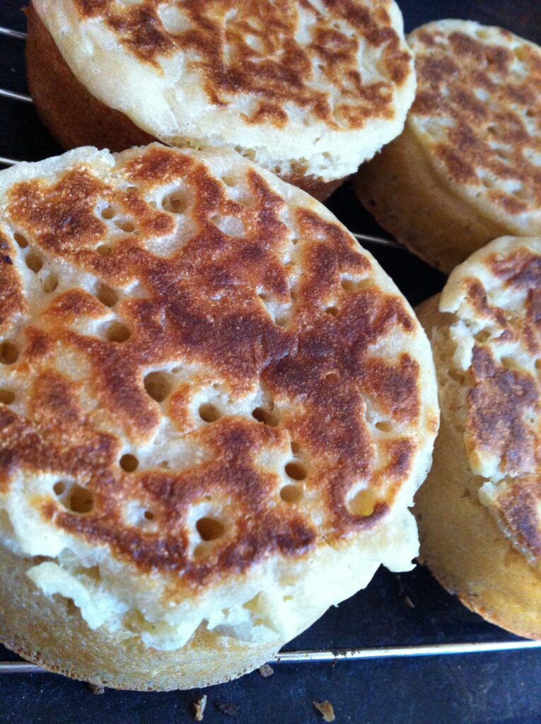 Crumpets cooling after being cooked on welsh bake stone