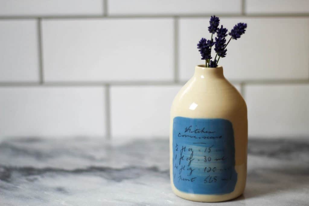 Ceramic milk bottle with kitchen conversions. Display on it's own or with a decorative flower.