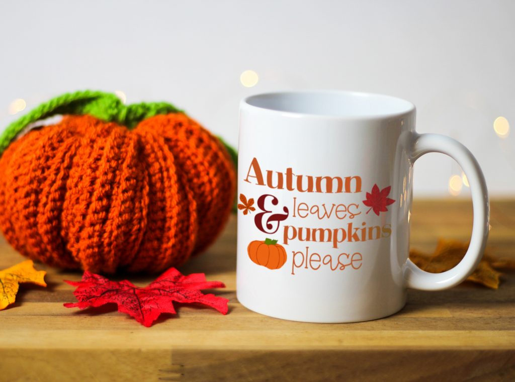 Ceramic white mug with an illustration of a pumpkin and the words autumn leaves and pumpkins please