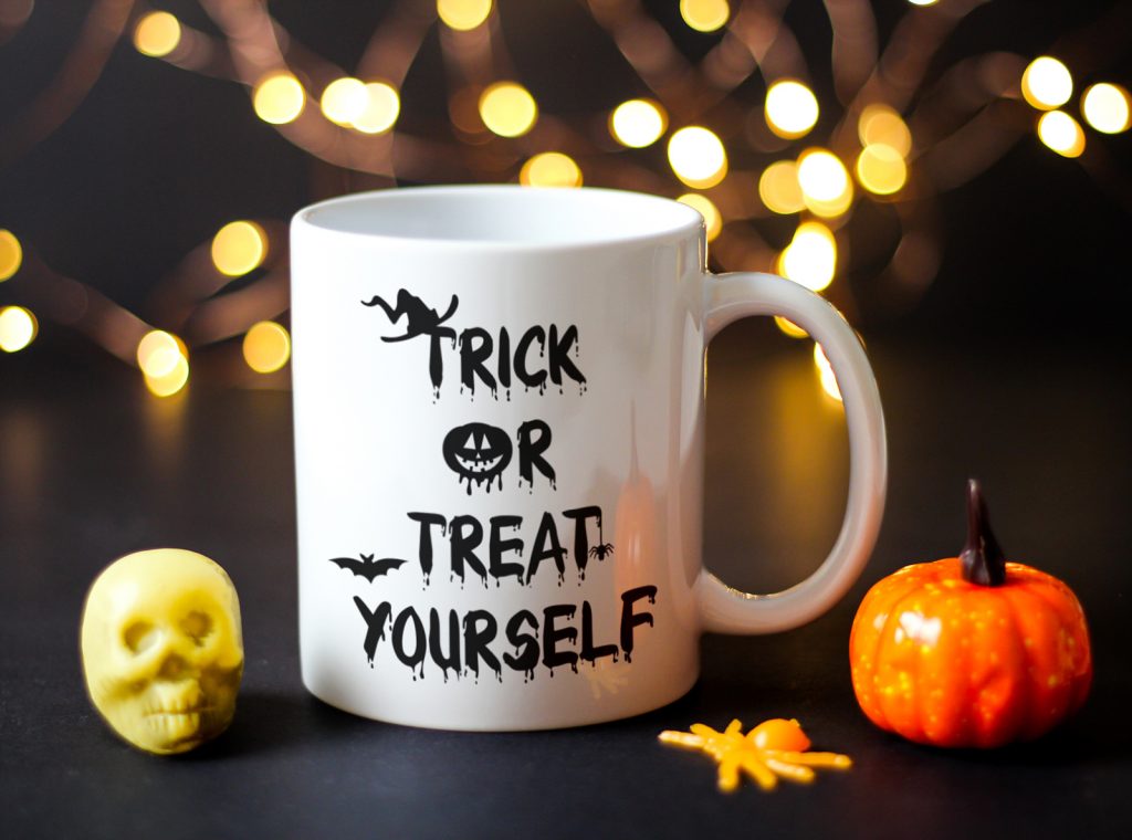 White ceramic Halloween mug which says trick or treat yourself