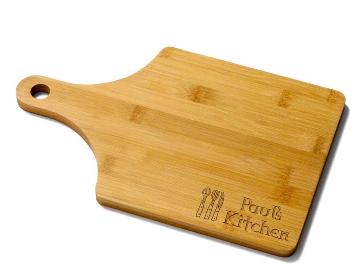 short paddle shaped bamboo board engraved with words Paul's Kitchen