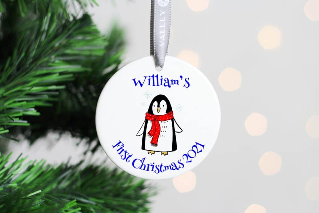 ceramic christmas tree decoration printed an image of a penguin and he words williams first christmas