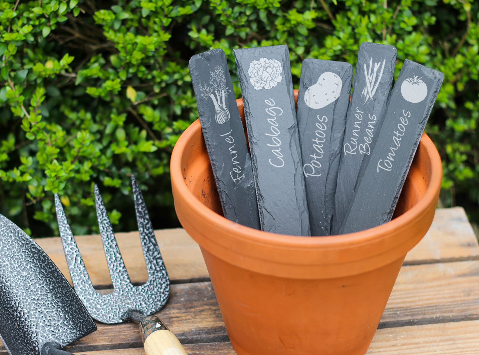 Hand-cut Welsh slate plant markers with a variety of differn vegetables engraved