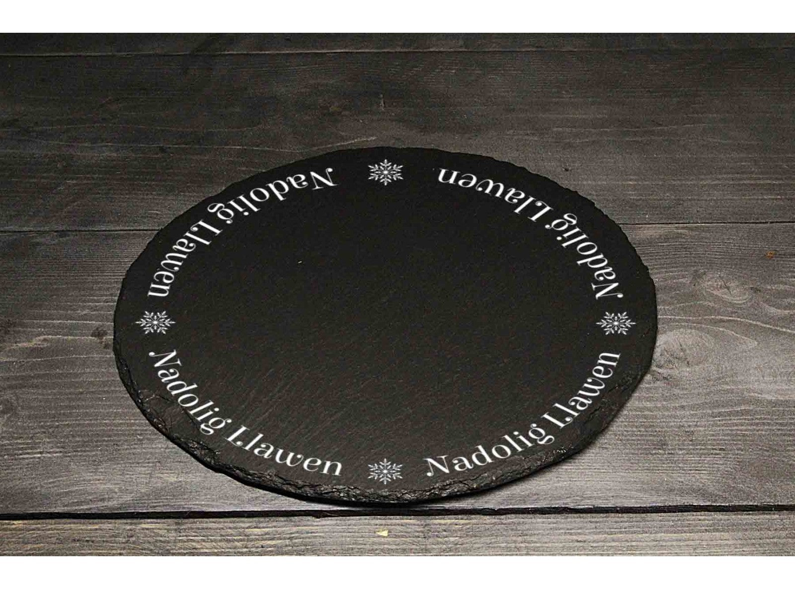 Hand-cut Welsh slate round Christmas cheese board engraved with the words 'Nadolig Llawen' (Merry Christmas in Welsh) 